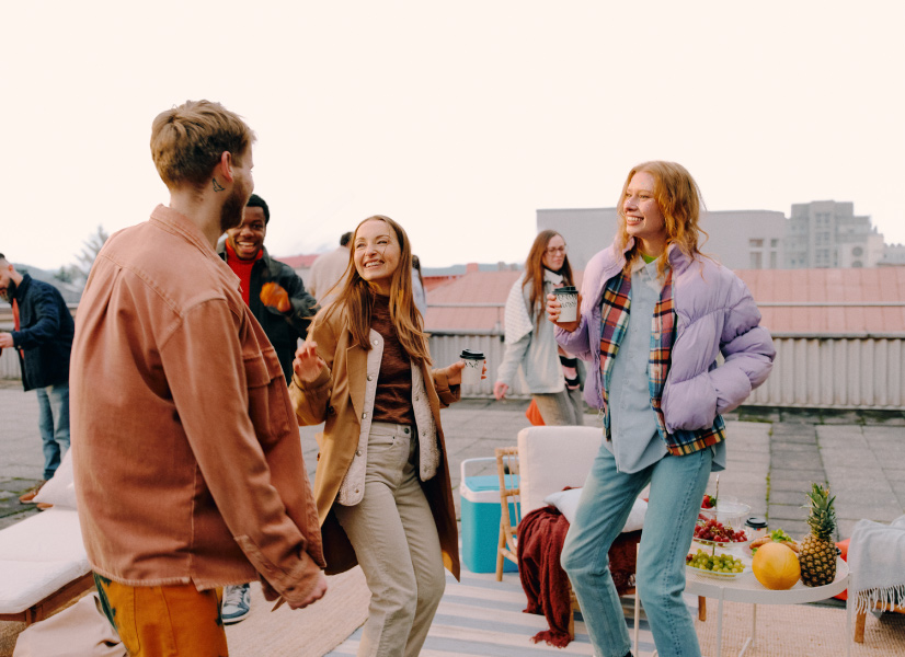 The group of friends is having a nice time at a picnic on the rooftop.
