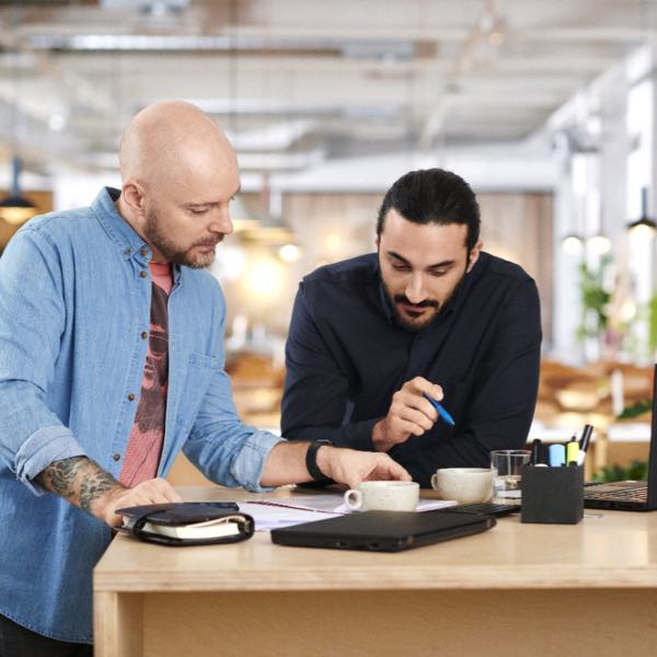 Two men discussing at a work table.
