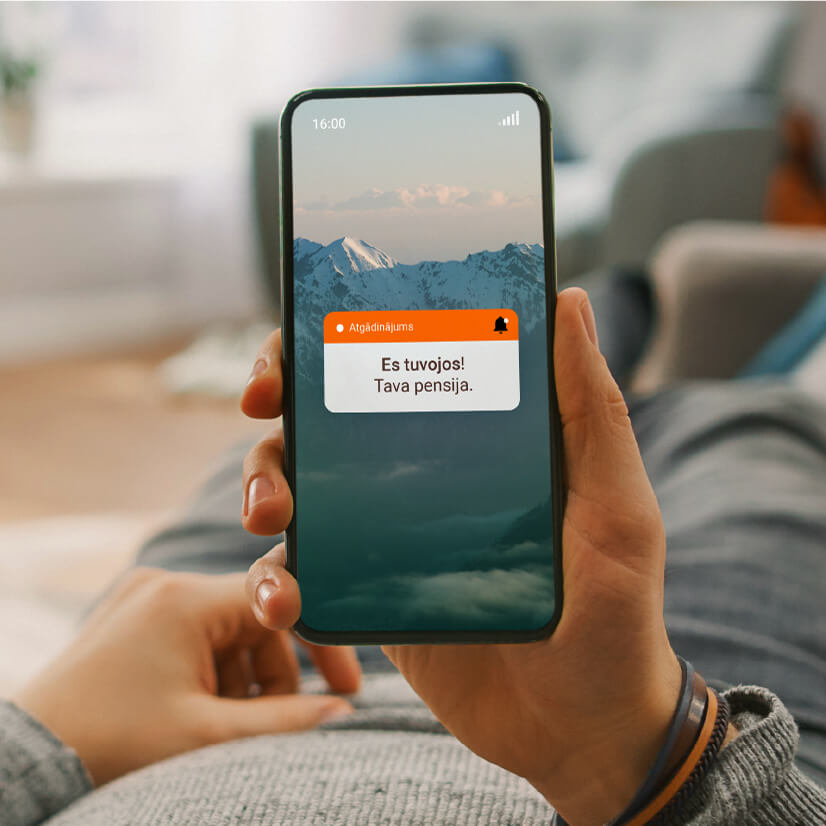 Mobilajā tālrunī redzams paziņojums “Es tuvojos! Tava pensija”, lai atgādinātu par piemērotākā Swedbank pensiju 2. līmeņa plāna izvēli.